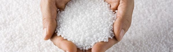 Plastic White Round Resin Pellets in a Holding Hand